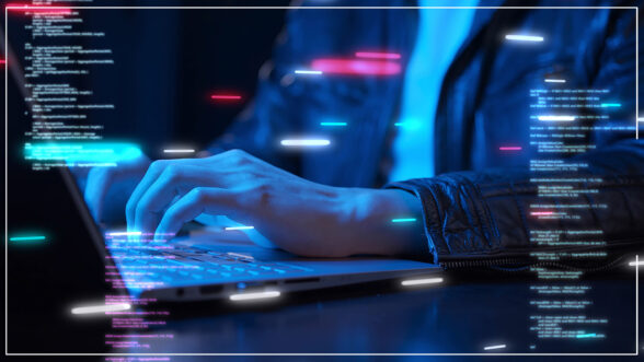 Moody image of a hacker with a computer with code overlayed on top