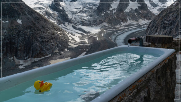 Image of an ice cold bath in the mountains with a yellow rubber ducky in the water.